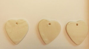 Cutting heart out of clay for Christmas ornaments