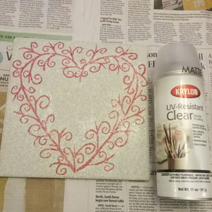 Spraying your painted ceramic tile with a clear acrylic coating