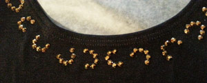Laying out pattern of rhinestones along neckline of dress