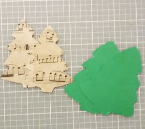 Christmas tree shapes cut out of sheet music and card stock
