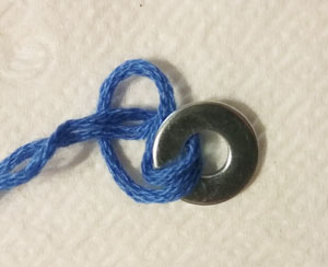 Using a cow hitch knot to secure a washer to make a bracelet