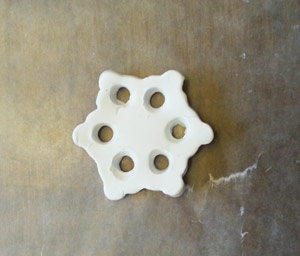 Cutting holes in the clay to make the snowflake