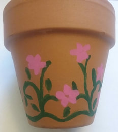 Painting flowers on a terra cotta pot for a DIY Easter gift