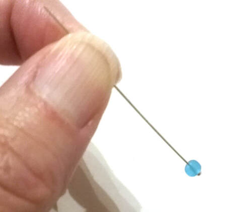Slide a bead onto the head pin to make paper bead earrings